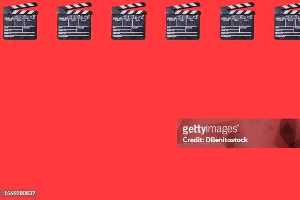 pattern of old wooden movie clappers with the word 'strike' written on it, on top, on a red background. concept of film industry, strike, actors, screenwriters, cinema, entertainment and hollywood. - film benefit stock pictures, royalty-free photos & images