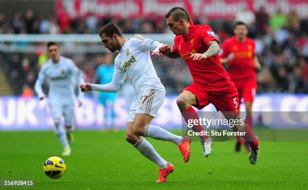 Liverpool player Daniel Agger challenges Swansea player Itay Shechter during the Barclays Premier League match between Swansea City and Liverpool at...