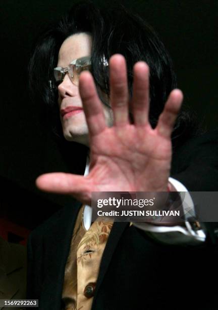 Entertainer Michael Jackson puts his hand toward the camera as leaves the courtroom at the Santa Barbara County Courthouse for a break during his the...