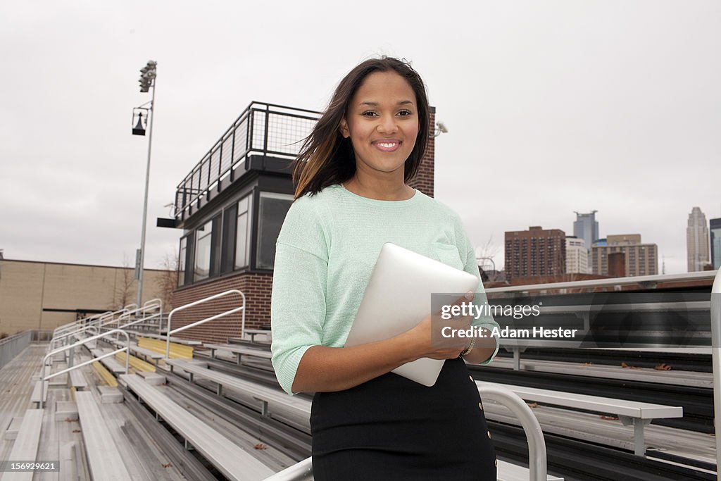 A young girl holding a tablet device outside.