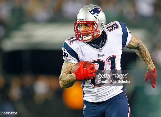 Tight end Aaron Hernandez of the New England Patriots runs after making a catch against the New York Jets in a game at MetLife Stadium on November...