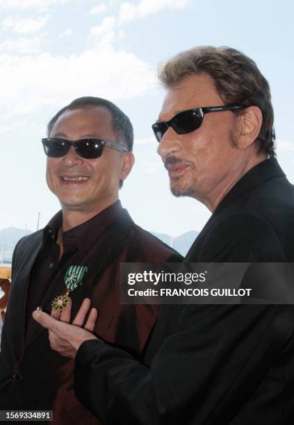 French actor and singer Johnny Hallyday congratulates Hong Kong's director Johnnie To after he received the "Officier dans l'Ordre national des Arts...