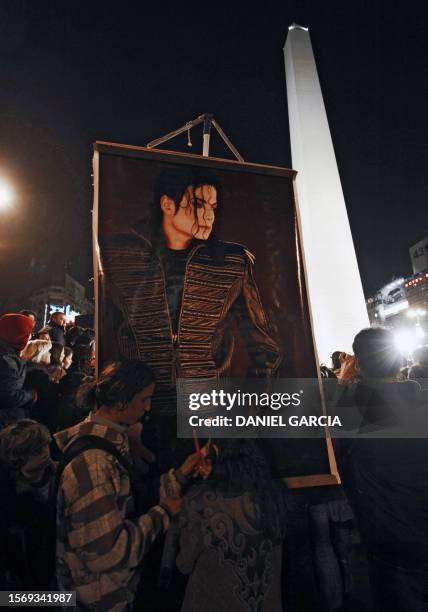 Argentine youths carry a poster to pay tribute to late singer Michael Jackson on June 26, 2009 near the Obelisk in Buenos Aires. Michael Jackson's...