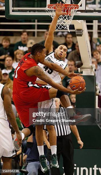 Shawn Long of the Louisiana-Lafayette Ragin' Cajuns tries to get a first half shot off past the defense of Denzel Valentine of the Michigan State...