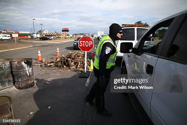 Patrolman Ryan Greenhalgh works at a check point making sure only residents and contractors enter on November 25, 2012 in Ortley Beach, New Jersey....