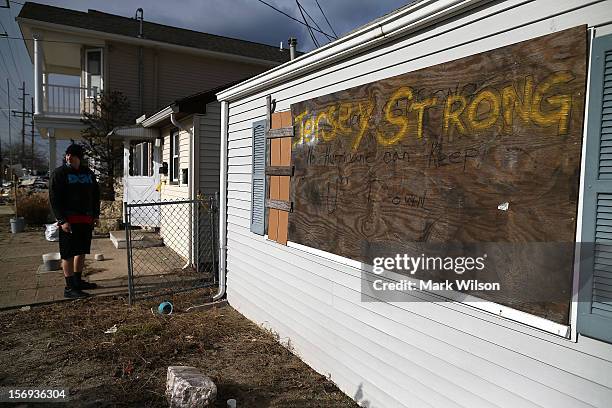 Man stands in front of his home that was flooded by Superstorm Sandy on November 25, 2012 in Seaside Heights, New Jersey. New Jersey Gov. Christie...