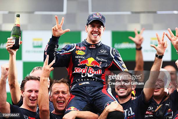 Sebastian Vettel of Germany and Red Bull Racing celebrates with team mates on the podium as he finishes in sixth position and clinches the drivers...