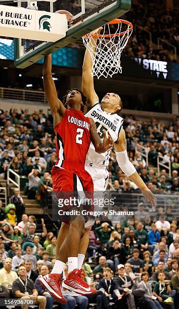 Elfrid Payton of the Louisiana-Lafayette Ragin' Cajuns gets to the basket for a second half layup in front of Denzel Valentine of the Michigan State...