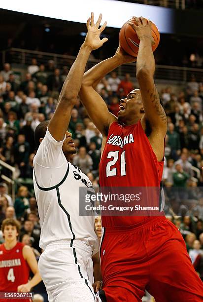 Shawn Long of the Louisiana-Lafayette Ragin' Cajuns tries to get a shot off over Adreian Payne of the Michigan State Spartans at the Jack T. Breslin...