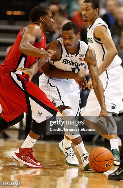 Keith Appling of the Michigan State Spartans tries to dribble around Bryant Mbamalu of the Louisiana-Lafayette Ragin' Cajuns during the second half...