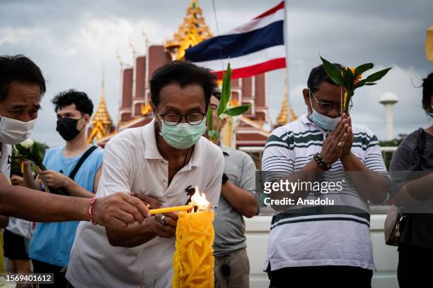 People light incense during pray ritual at Wat Asokaram on Asalha Puja Day in Samut Prakan, Thailand on August 1, 2023. Asalha Puja Day, also known...