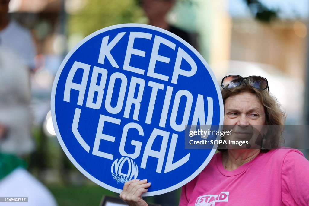 A woman holds a placard saying , "Keep Abortion Legal,"...
