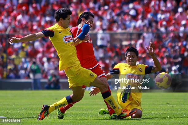 Antonio Rios of Toluca fights for the ball with Jesus Zavala and Juan Carlos Medina of America during a match between Toluca and America as part of...