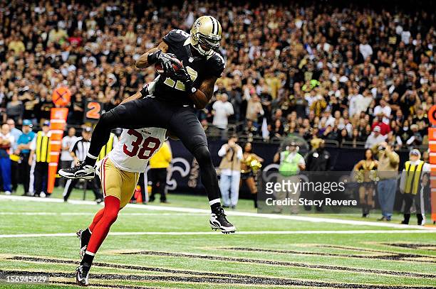 Marques Colston of the New Orleans Saints catches a touchdown pass in front of Dashon Goldson of the San Francisco 49ers during a game at the...