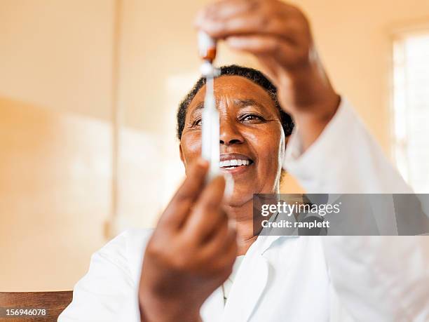 afrikanischen krankenschwester mit einem impfstoff - doctors in africa stock-fotos und bilder