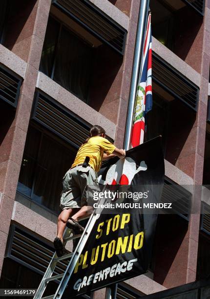 An activist of Greenpeace places a poster on the British flag pole, wichi say "Stop Plutonium", in the British Embassy in Buenos Aires, Argentina, 05...