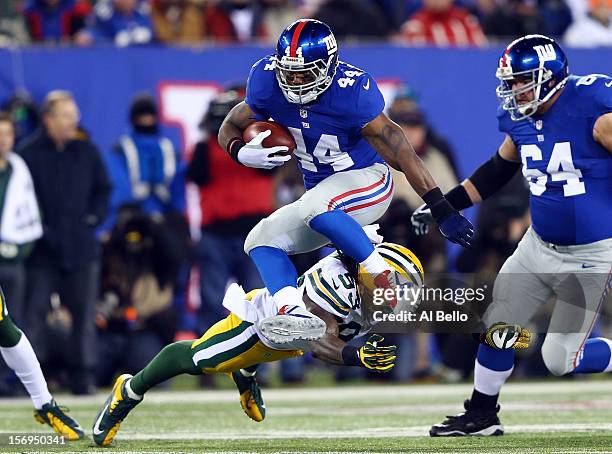 Running back Ahmad Bradshaw of the New York Giants jumps over the tackle of outside linebacker Erik Walden of the Green Bay Packers at the begining...