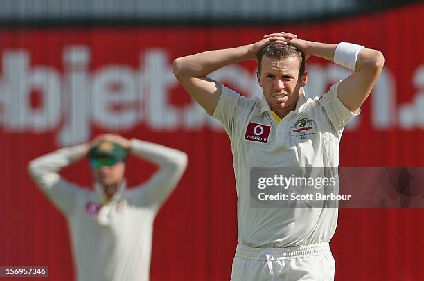 Michael Clarke and Peter Siddle of Australia look on after Ed Cowan dropped a catch off Siddles bowling during day five of the Second Test Match...