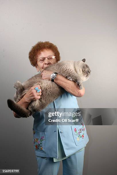 Rosa Wardle poses for a photograph with her cat named 'Blue Snowman' after being exhibited at the Governing Council of the Cat Fancy's 'Supreme...