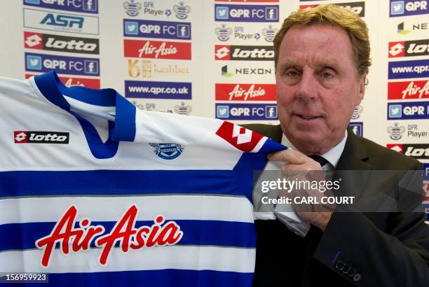 New Queens Park Rangers football club manager Harry Redknapp holds up a team jersey before a press conference in west London on November 26 to...