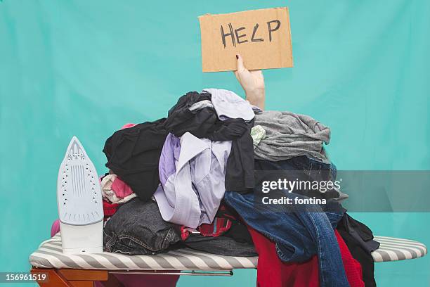 woman ironing, hidden by large pile of laundry - bügelbrett stock-fotos und bilder