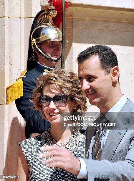 Syrian President Bashar al-Assad and his wife Asma arrive at the Elysee palace on July 14, 2008 in Paris, to attend the traditional garden party as...