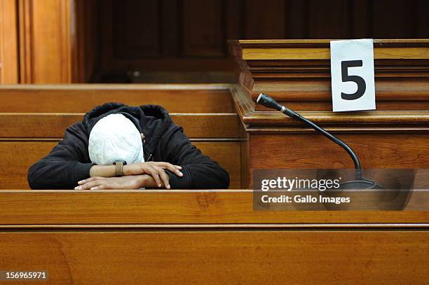 Accused murderer Xolile Mngeni rests his head in the Cape Town High Court on November 26, 2012 in Cape Town, South Africa. Mngeni was found guilty of...