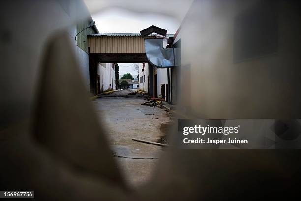 The abandoned terrain of the Mavisa door factory is seen through a broken roll up door on November 22, 2012 in Villacanas, Spain. During the boom...