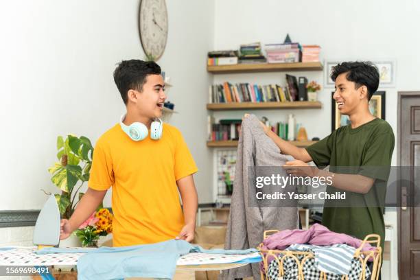 brothers doing laundry day - man washing basket child stock pictures, royalty-free photos & images