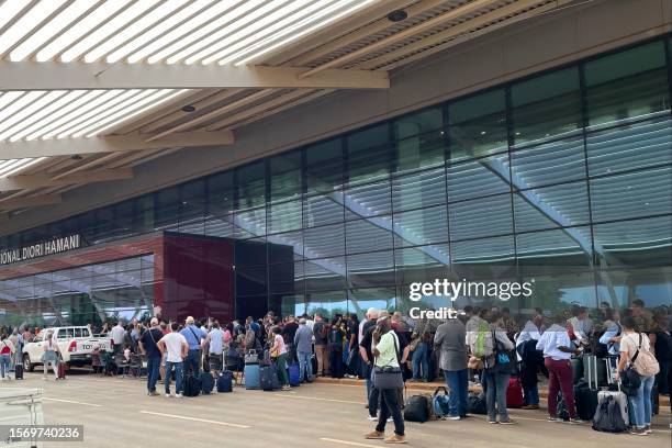 Passengers are seen outside the Diori Hamani International Airport in Niamey on August 1, 2023. French and European citizens were to be evacuated on...
