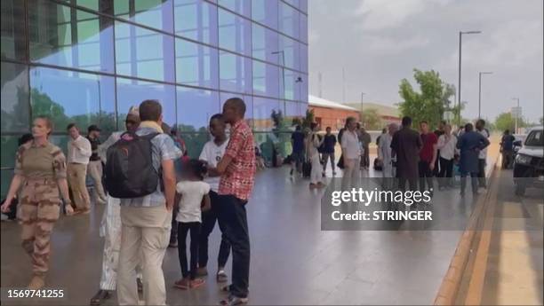 This screen grab made from AFPTV video footage shows French, and other European citizens waiting outside the departures terminal of Niamey's...