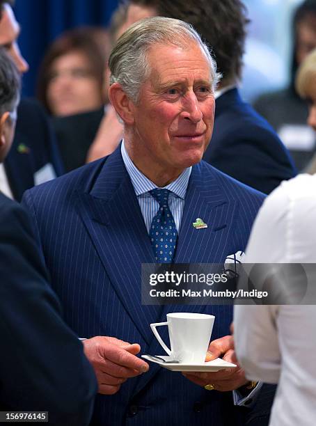 Prince Charles, Prince of Wales holds a cup and saucer as he, accompanied by Jamie Oliver, visits Carshalton Boys Sports College to see how the...