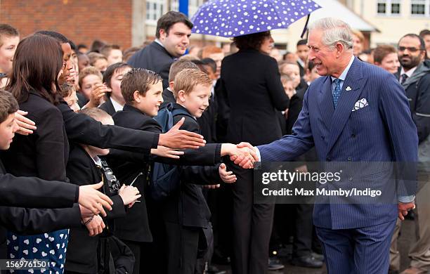 Prince Charles, Prince of Wales shakes hands with pupils as he, accompanied by Jamie Oliver, visits Carshalton Boys Sports College to see how the...