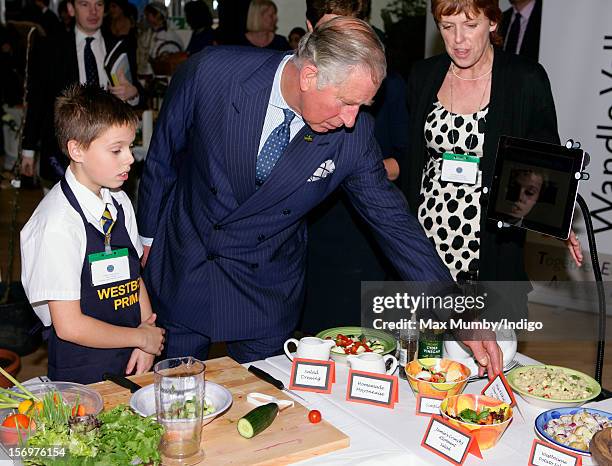 Prince Charles, Prince of Wales talks with a school boy doing a cookery demonstration as he, accompanied by Jamie Oliver, visits Carshalton Boys...
