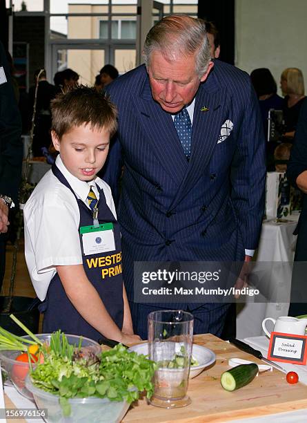 Prince Charles, Prince of Wales talks with a school boy doing a cookery demonstration as he, accompanied by Jamie Oliver, visits Carshalton Boys...