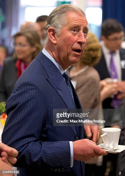 Prince Charles, Prince of Wales holds a cup and saucer as he, accompanied by Jamie Oliver, visits Carshalton Boys Sports College to see how the...