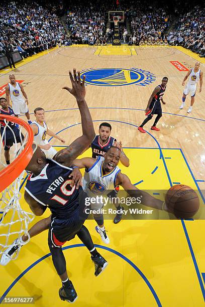 Carl Landry of the Golden State Warriors puts up a shot against Johan Petro of the Atlanta Hawks on November 14, 2012 at Oracle Arena in Oakland,...