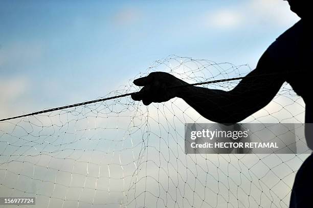 By Blanca Morel Thirty-five-year-old fisherman Adonis Mena, throws his fishing net into the waters of Xolotlan Lake, also known as Lake Managua, one...