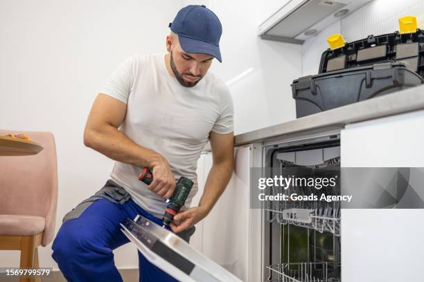manitas instalando un lavavajillas empotrado - técnica de imágenes fotografías e imágenes de stock