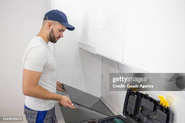man assembling stove - handyman stockfoto's en -beelden