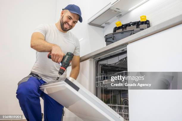 handyman installing a dish washer - appliance service stock pictures, royalty-free photos & images