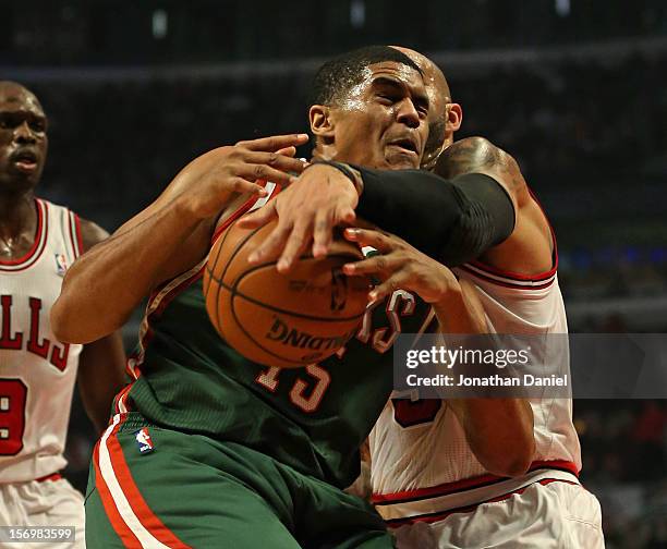 Tobias Harris of the Milwaukee Bucks is fouled by Carlos Boozer of the Chicago Bulls at the United Center on November 26, 2012 in Chicago, Illinois....