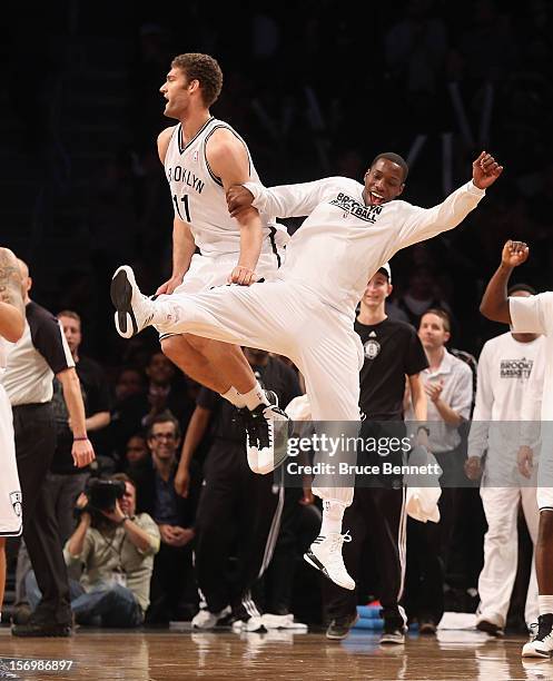 Tyshawn Taylor of the Brooklyn Nets bumps Brook Lopez following Lopez's bucket late in the fourth quarter against the New York Knicks at the Barclays...