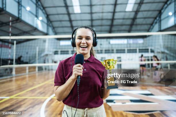 portrait of a young woman tv reporter holding a trophy on the sports court - tv reporter 個照片及圖片檔