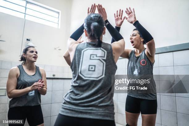 female volleyball team greeting with high-five in the locker room - pre game huddle stock pictures, royalty-free photos & images