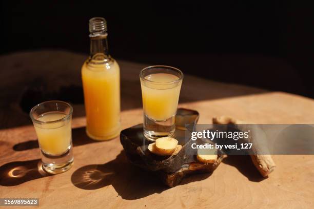 ginger shots on a wooden surface - schnapsglas stock-fotos und bilder