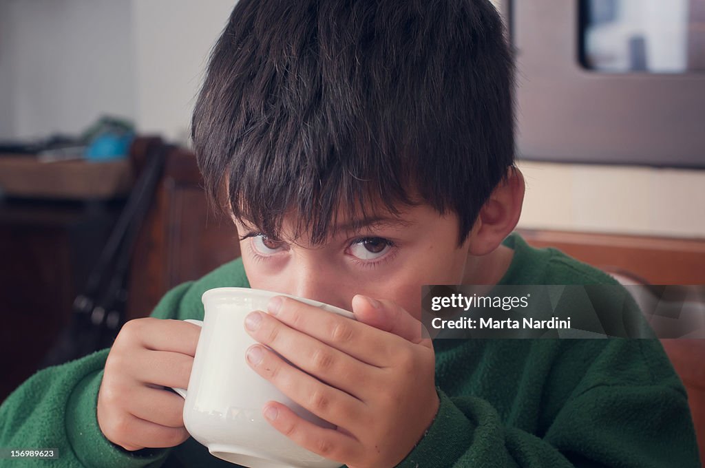 Boy drinking from a large cup