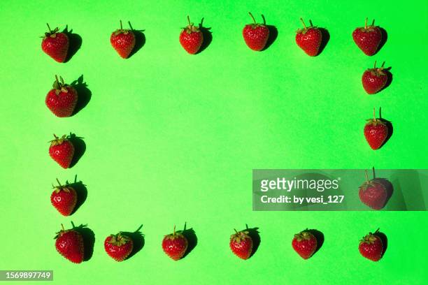 flat lay, frame of strawberries on green background - succulent frame stock pictures, royalty-free photos & images
