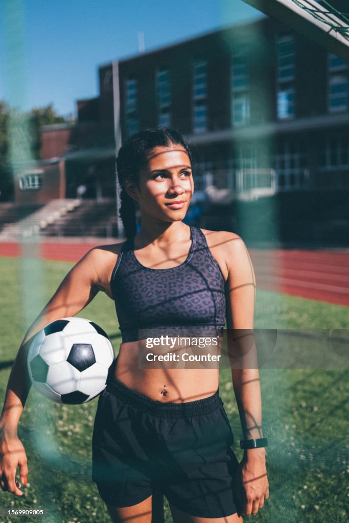Woman with soccer ball in sports field