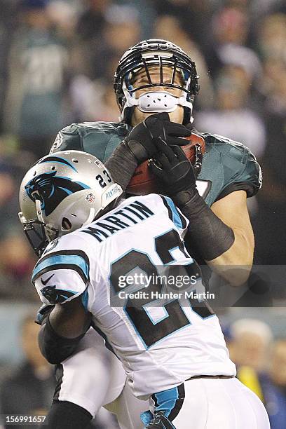 Tight end Brent Celek of the Philadelphia Eagles gets hit by free safety Sherrod Martin of the Carolina Panthers after catching a pass during a game...